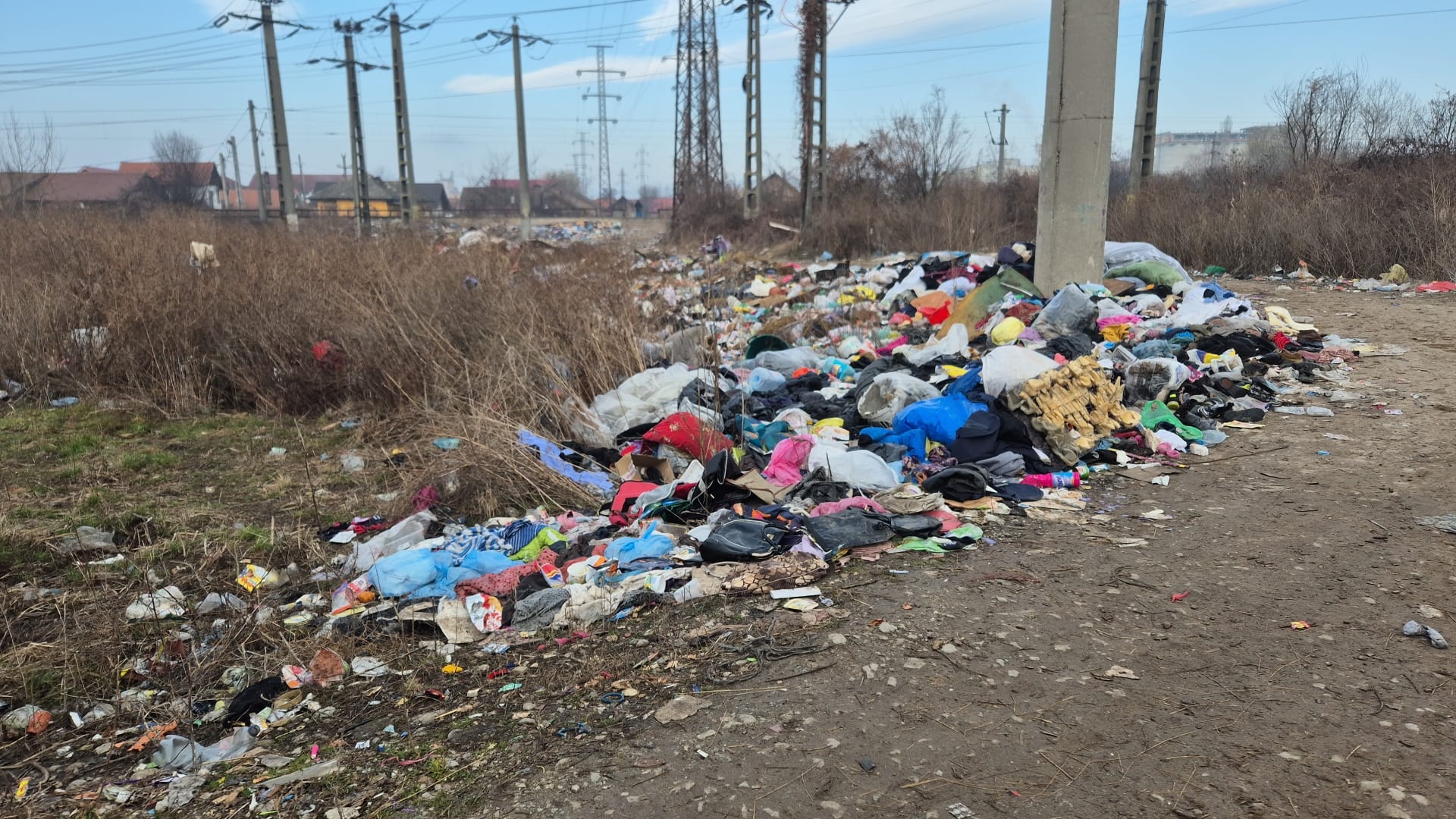 Peisaj dezolant la marginea orașului Târgu Jiu: câmpuri sufocate de haine vechi. Cât cheltuie primăria pentru a curăța periodic zona