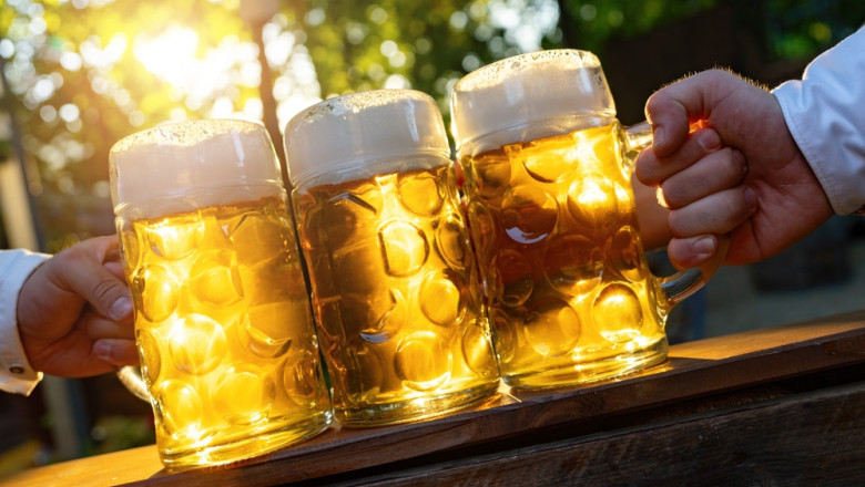 Hands,Holding,Bavarian,Beer,Mugs,With,Sunlight,From,The,Background