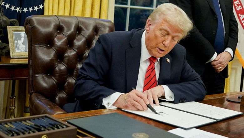 President Donald Trump signs an executive order in the Oval Office of the White House
