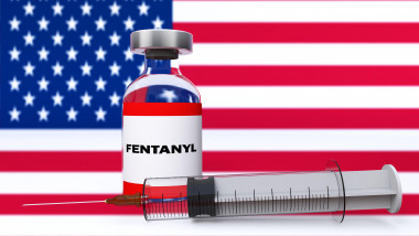 Spectacular bottle of fentanyl citrate with a syringe against a UNITED STATES OF AMERICA FLAG'S USA background. 3D render.