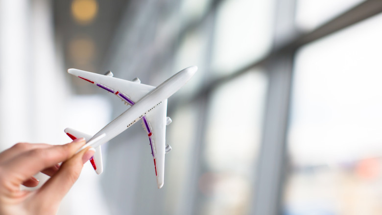 Close,Up,Hand,Holding,An,Airplane,Model,At,Airport