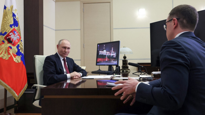 Russia's President Vladimir Putin speaks with Russian TV journalist Pavel Zarubin at his desk at the Novo-Ogaryovo state residence outside Moscow