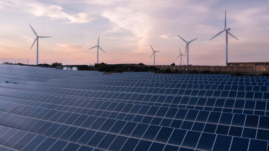 Solar panels and wind turbines producing green energy for clean environment.