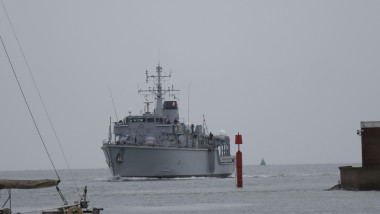 At the mouth of the harbour, passing a red marker: HMS Cattistock, a Royal Navy Hunt Class minesweeper returns to her home base, Portsmouth, after having been involved in a week-long operation to monitor two Russian Navy task groups passing the UK, worki