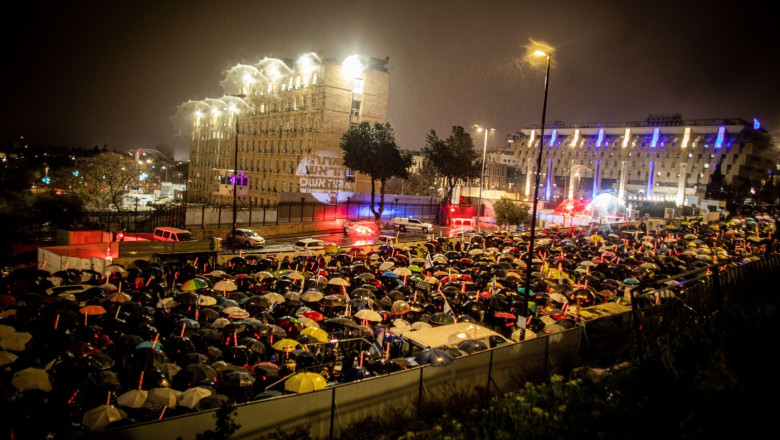 Israeli demonstrators stand in poring rain as they protest outside PM, office in Jerusalem, Thursday, March 20 2025. The Israeli cabinet voted early on Friday to dismiss the head of the Shin Bet domestic intelligence service effective April 10, Prime Mini
