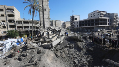 Palestinians inspect a crater at the site of Israeli strikes on a makeshift displacement camp in central Gaza City