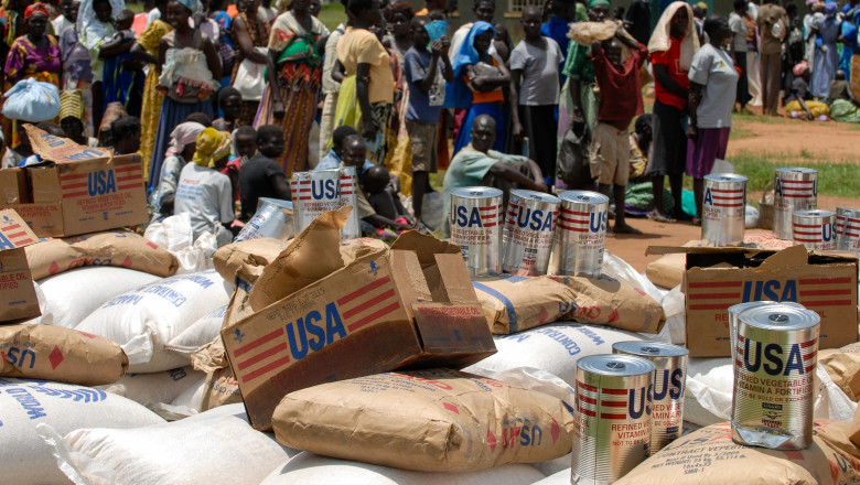 UGANDA, Kitgum , World Food Programme, distribution of EU aid maize and USAID cans with vegetable oil for internal displaced refugees of civil war between LRA and Ugandanian army