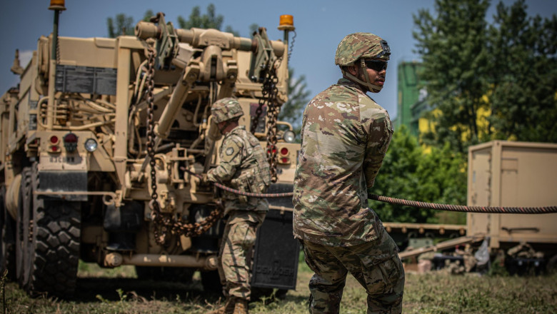 U.S. troops connect towing cables between two tactical vehicles during a towing and recovery training session with Romanian, Bulgarian, and Albanian forces in Slobozia, Romania, May 30, 2023. Saber Guardian 23, a component of DEFENDER 23, is an exercise c