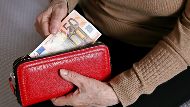 Elderly woman takes out a euro note from her wallet. Concept of pension payments, savings at retirement, pensioner with money