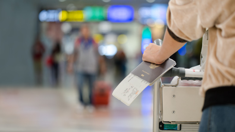 Closeup,Of,Girl,Holding,Passports,And,Boarding,Pass,At,Airport