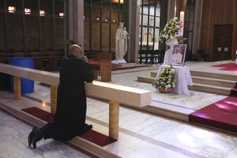 Father Lawrence Mduduzi Ndlovu prays in front of a shrine dedicated to the late Pope Francis at the Cathedral of Christ the King Catholic Church in Johannesburg on April 21, 2025.