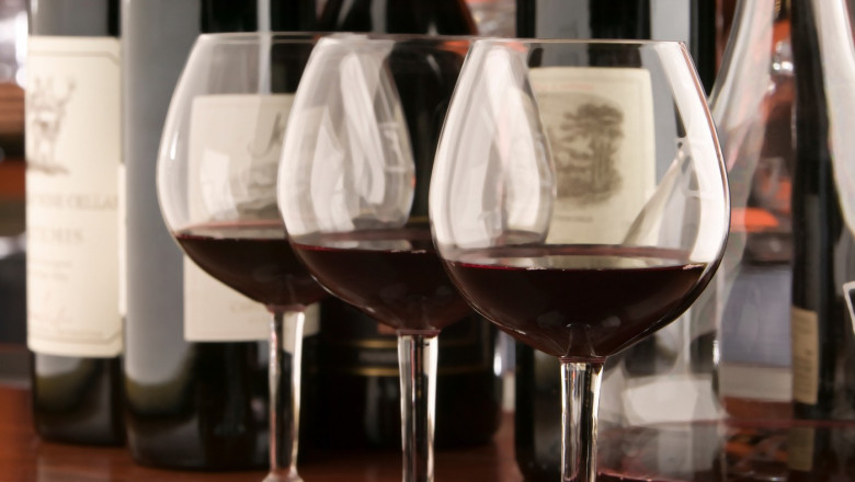 Three red wine glasses and bottles