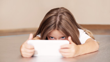 Little,Girl,Child,Uses,Smartphone,,Looks,At,Screen,,Plays,Or