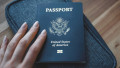 Woman's,Fingers,Holding,Passport,Of,Usa,(united,States,Of,America)