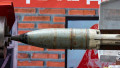 A,Large,,Rusted,Missile,Is,Clamped,Securely,Within,A,Metal