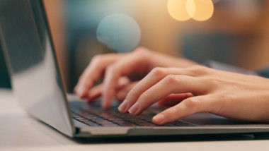femeie care scrie la laptop