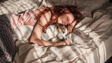 Young,Woman,Is,Lying,And,Sleeping,With,Dog,In,Bed