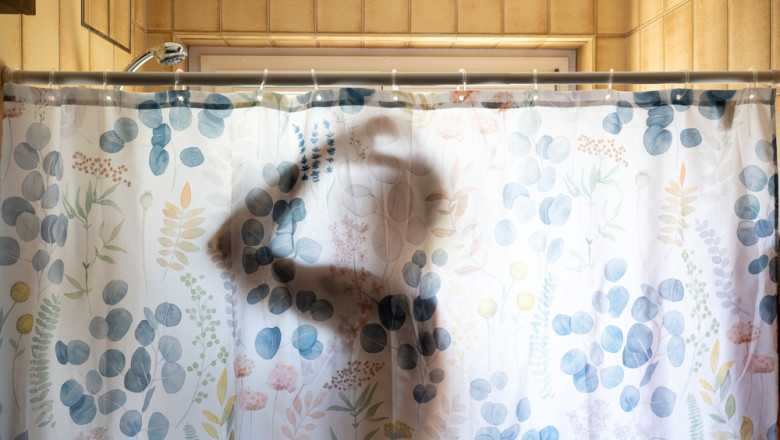 Unrecognizable,Man's,Silhouette,Taking,A,Shower,,Seen,Through,A,Shower