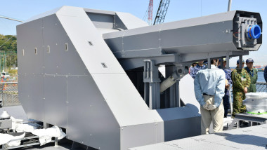 A new turret mounted electromagnetic railgun is mounted on the deck of the Japan Maritime Self-Defense Force JS Asuka. The image was taken during a visit to the ship by Vice Adm. Omachi Katsushi, commander of the Self-Defense Fleet.
