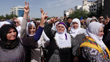 A group of Kurdish women are seen making the victory sign at a commemoration ceremony.