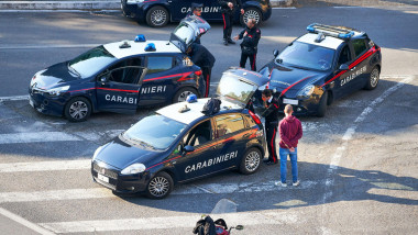 Rome, Italy - April 8, 2020: Man on scooter is stopped at checkpoint by eight Italian Carabinieri and charged with violating coronavirus lockdown