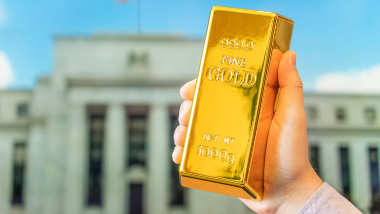 a gold bar in a man's hand against the background of the central bank, US Federal Reserve system.