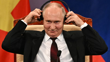 Vladimir Putin își pune o pereche de căști pe urechi