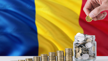 Business man holding coins putting in glass, Romania flag waving in the background. Finance and business concept. Saving money.