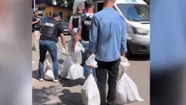 politisti care cara saci cu bani recuperati dupa furtul de la posta