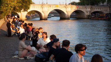 France weather, 11 June 2025: As the city of Paris starts a heatwave temperatures rose to 27 centigrade and are expected to hit 31 C tomorrow. On the Isle de la Cite in the evening hundreds of locals and tourists crowded onto the banks of the river Seine