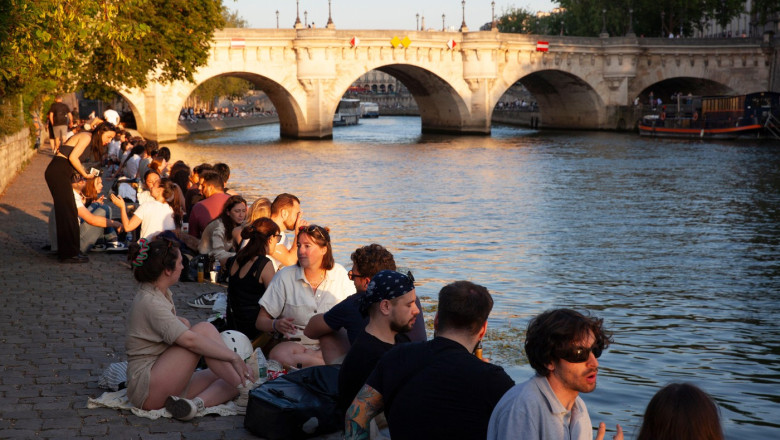 France weather, 11 June 2025: As the city of Paris starts a heatwave temperatures rose to 27 centigrade and are expected to hit 31 C tomorrow. On the Isle de la Cite in the evening hundreds of locals and tourists crowded onto the banks of the river Seine
