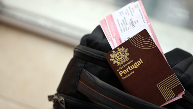 Red Portugal passport of European Union with airline tickets on touristic backpack close up. Tourism and travel concept. Red Portugal passport of