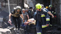 first responders evacuating a wounded person from the rubble of a building following a Russian missile strike in the eastern Ukrainian city of Dnipro