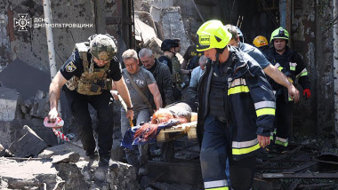 first responders evacuating a wounded person from the rubble of a building following a Russian missile strike in the eastern Ukrainian city of Dnipro