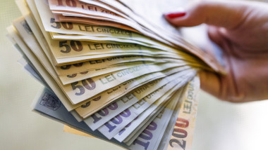 o femeie cu mai multe bancnote in mana