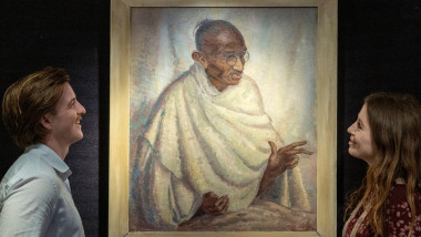London, UK. 11 July 2025. Staff members with ‘Portrait of Mahatma Gandhi, 1931, by Clare Leighton (Estimate £50,000 - £70,000), thought to be the only oil portrait that Gandhi actually sat for and the highlight of Bonhams’ Travel and Exploration sale at