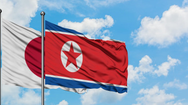 Japan and North Korea flag waving in the wind against white cloudy blue sky together. Diplomacy concept, international relations.
