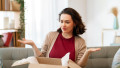 Woman is unpacking cardboard. Concept of frustrated online shopping.