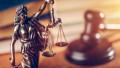 statuie a justitiei si un ciocanel de judecator