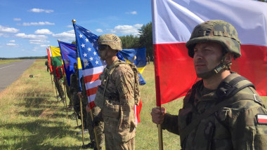 Soldiers representing NATO nationals stand with flags during opening ceremonies for exercise Anakonda June 6, 2016 in Oleszno, Poland. Troops from 21 NATO nations are taking part in Anakonda 2016 exercises in Poland, the largest such exercise since the co
