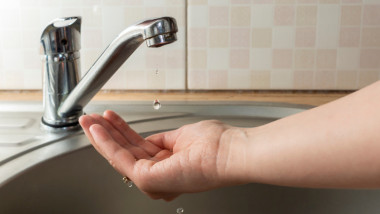un robinet de la care curge doar o picatura de apa