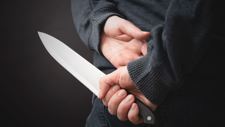 Close-up on the murderer holding the murder weapon. Man with a knife in his hand