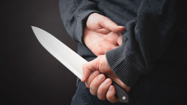 Close-up on the murderer holding the murder weapon. Man with a knife in his hand