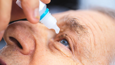 Elderly person puts eye drops in the eye. Senior man putting eye drop