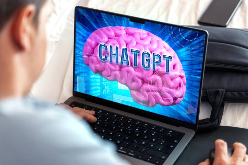 27 September 2023: Artificial intelligence and chatbot ChatGPT website on a brain in a laptop computer. Man in front of