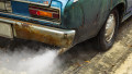 Vintage old car emits pollutant out of the exhaust