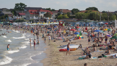 Persoane stau la plajă în localitatea 2 Mai din județul Constanța, 19 iulie 2025.