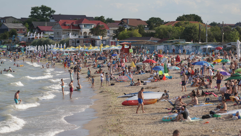 Persoane stau la plajă în localitatea 2 Mai din județul Constanța, 19 iulie 2025.
