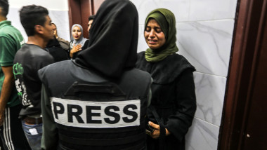 Relatives of one of five Palestinian journalists killed in an Israeli airstrike on Nasser Hospital mourns over his body ahead of the funeral in Khan Yunis