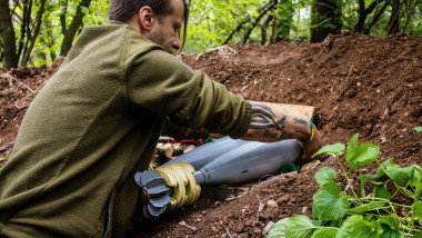Ukrainian soldier of the 28th Artillery Battalion preparing a shell for a 120mm mortar on a Russian target on the zero line in the forest near Bakhmut